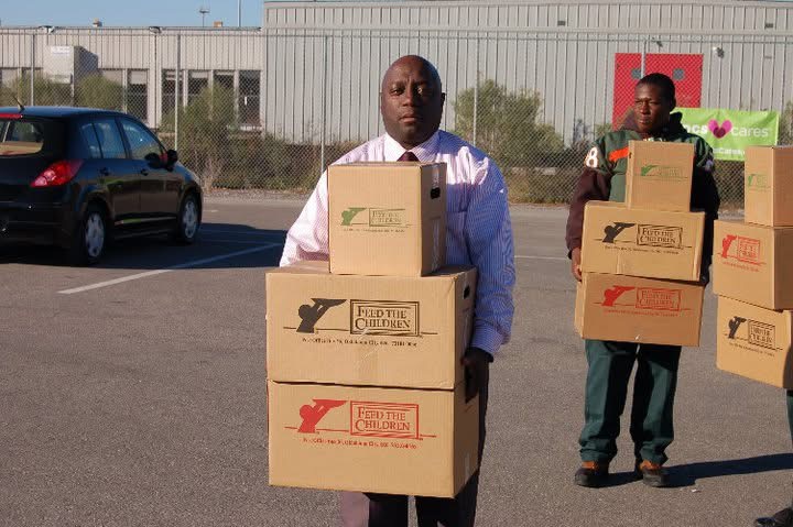 Willie Jones and a student volunteer holding boxes of donated food