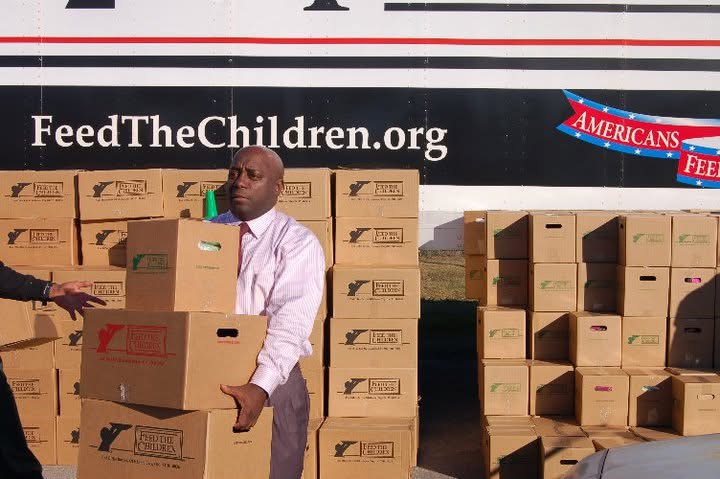 Willie Jones carrying a Feed the Children box at a community distribution event